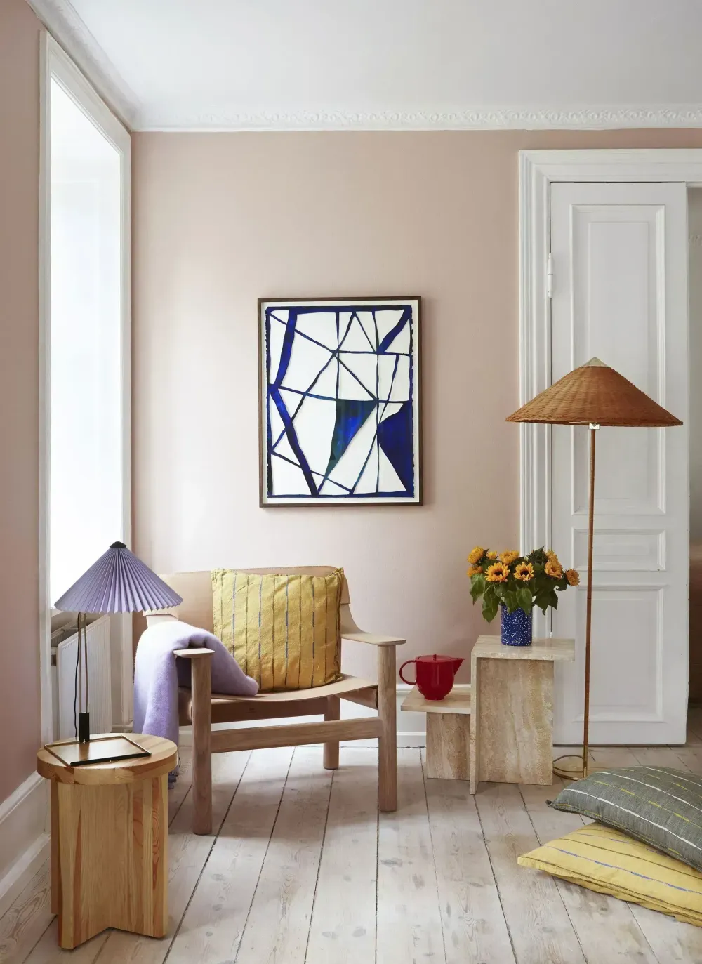 Canto de leitura, em uma sala, com paredes pintadas com bege suave.