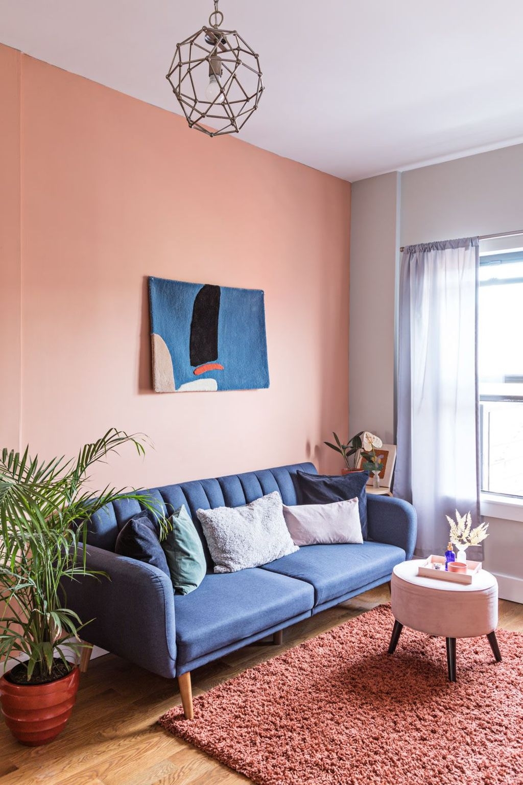 Sala com cores suaves, sendo uma parede pintada com laranja claro.