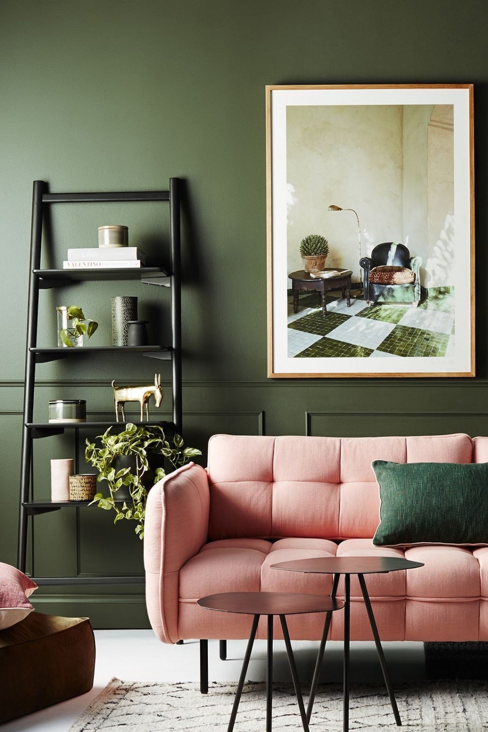 Sala pintada com um tom de verde mais fechado e decorada com alguns objetos da cor rosa.